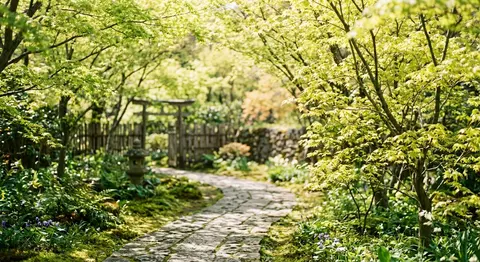 若葉がやわらかな風にきらめく午後、淡い黄緑と陽だまりの蜂蜜色に包まれた情景。春の息吹をまとった静かな庭園の小径に、透けるような新芽の葉影が揺れ、木漏れ日がやさし - AI生成图片 1