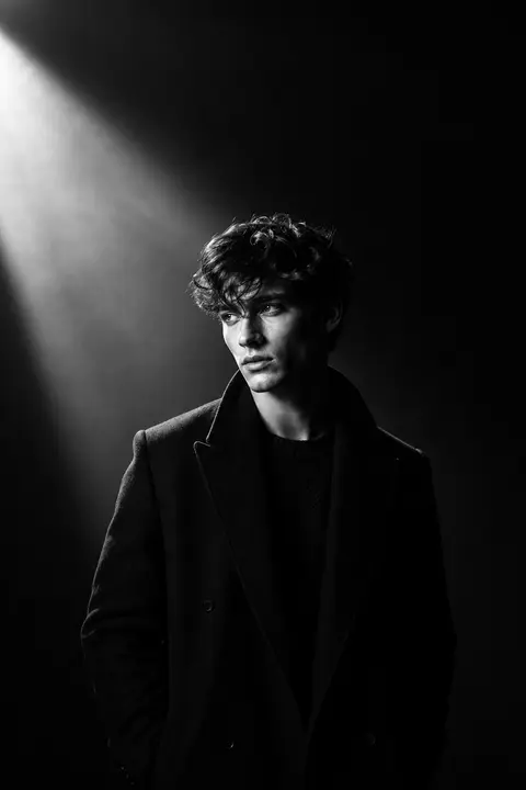 Ultra-cinematic black-and-white portrait of a young man standing in a dark minim - AI生成图片 2
