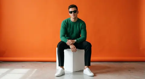 A stylish fashion muse named Adrian Vale sits atop a crisp white cube in a minim - AI生成图片 2