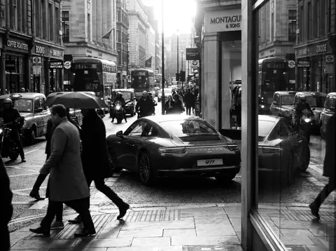 A stunning Porsche 911 parked confidently in the center of a bustling metropolit - AI生成图片 2