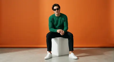 A stylish fashion muse named Adrian Vale sits atop a crisp white cube in a minim - AI生成图片 3