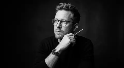 A dramatic black and white studio portrait of a thoughtful man with short styled - AI生成图片 2