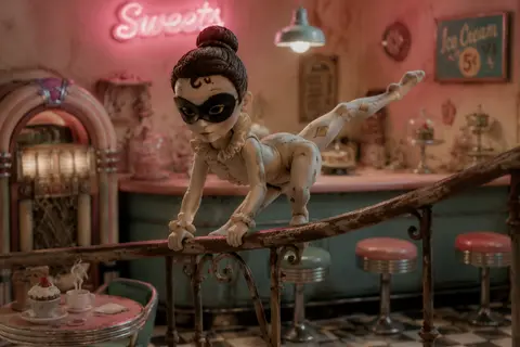A masked carnival acrobat poised in a silent 1950s retro diner, rendered as clay - AI生成图片 2