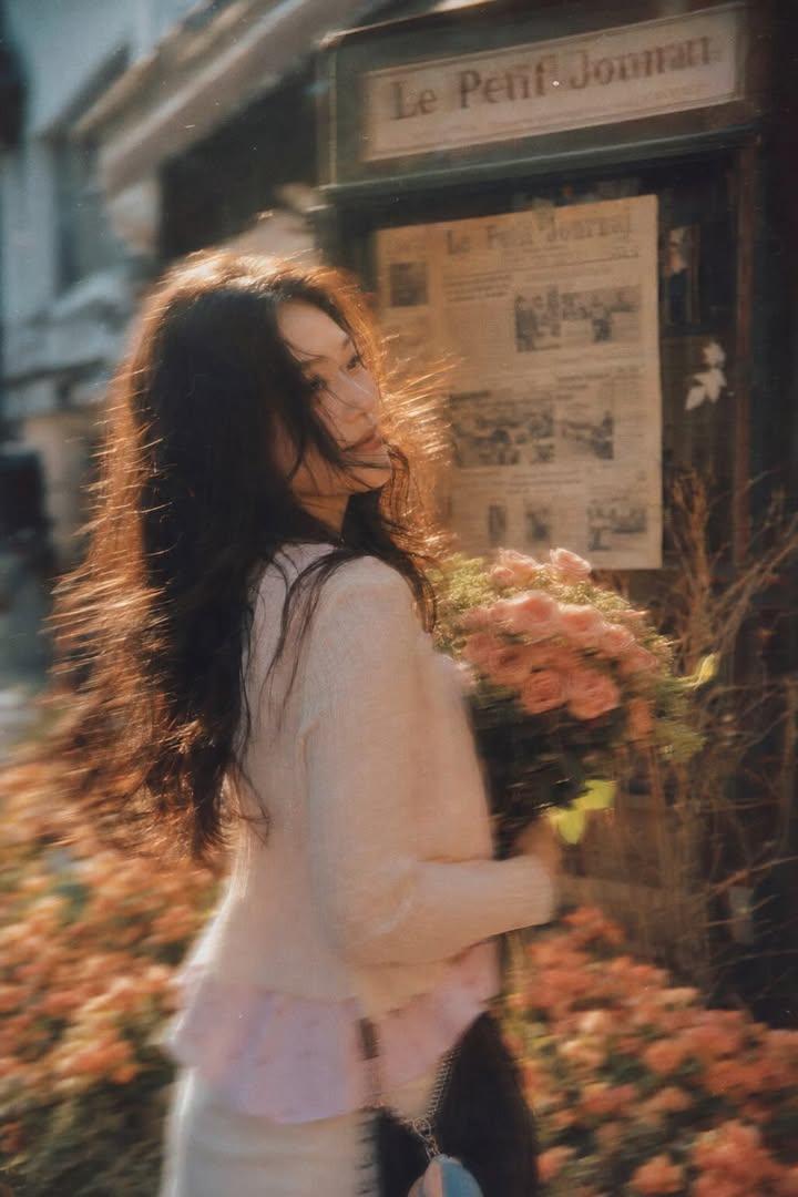 A beautiful young woman with long dark flowing hair holding a bouquet of soft pi - AI生成图片 2